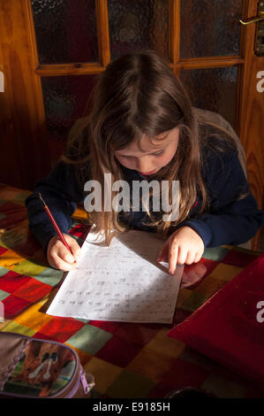 Seven year old Irish girl doing homework on kitchen table in Donegal Ireland Stock Photo