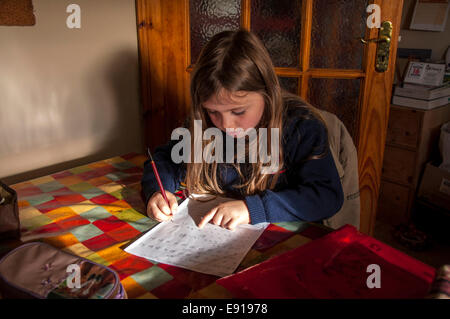 Seven year old Irish girl doing homework on kitchen table in Donegal Ireland Stock Photo