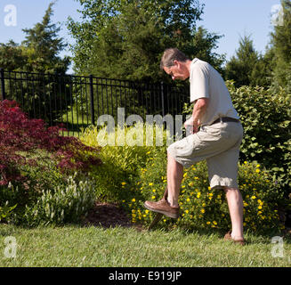 Senior man digging in garden Stock Photo