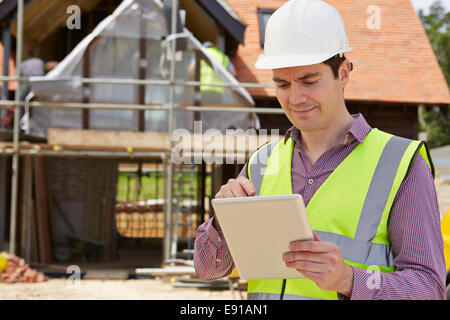 Architect On Building Site Using Digital Tablet Stock Photo