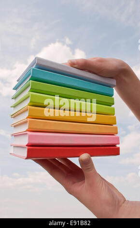 Hands holding color hard cover books Stock Photo