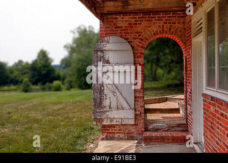 Open wooden door in brick wall to garden Stock Photo