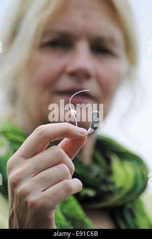 Modern small hearing aid in the palm of a woman Stock Photo