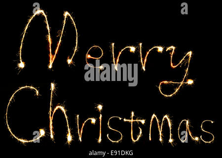 burning sparkler stick and writing Merry Chistmas sparkling words on black background