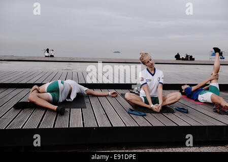 Thessaloniki, Greece. 17th Oct, 2014. Women rowers stretch before a race during the first day of the 2014 World Rowing Coastal Championship in the northern Greek city of Thessaloniki.  More than 350 competitors from 23 nations take part Credit:  Giannis Papanikos/Alamy Live News Stock Photo