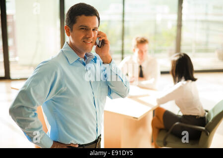 Hispanic Businessman Cell Phone Meeting Stock Photo