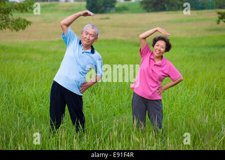 happy asian Senior couple doing gymnastics in the park Stock Photo