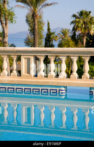 Colònia de Sant Pere, Mallorca, Balearic Islands, Spain. Stone balustrade reflected in pool of luxury apartment complex. Stock Photo