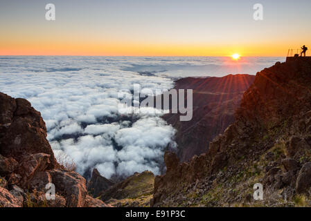 Photographer shooting a breathtaking mountain valley at sunset. Stock Photo