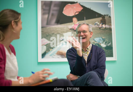 Hanover, Germany. 16th Oct, 2014. British photographer Martin Parr smiles during an interview at his exhibition 'Martin Parr. We love Britain!' at Sprengel museum in Hanover, Germany, 16 October 2014. The exhibtion feature photographs from the 1970s some of which where taken in Lower Saxony and will run until 22 February 2015. Photo: Jochen Luebke/dpa/Alamy Live News Stock Photo