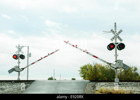 Train rail crossing arms coming down.  Lights flashing. Stock Photo
