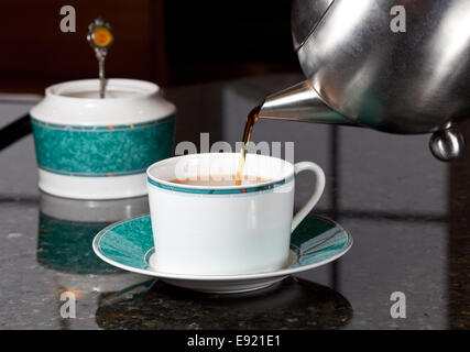 Tea poured from stainless steel teapot Stock Photo