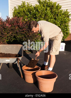 Senior man digging soil in wheelbarrow Stock Photo - Alamy