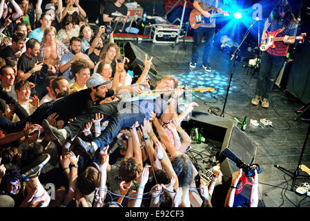 BARCELONA - MAY 30: The guitar player of Ty Segall (band) performs above the spectators (crowd surfing or mosh pit) Stock Photo