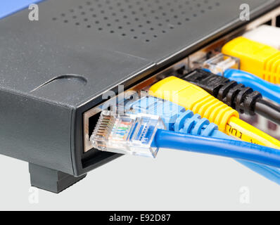 Cat 5 cables in multiple colors in router Stock Photo