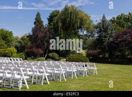 Rows of wooden chairs set up for wedding Stock Photo