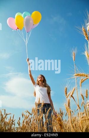 Teen girl at a wheat field with balloons Stock Photo - Alamy