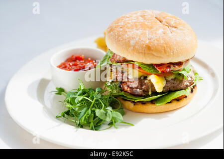 Beefburger on a plate with salsa sauce and salad Stock Photo