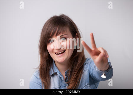 ordinary successful girl showing off fingers of victory Stock Photo