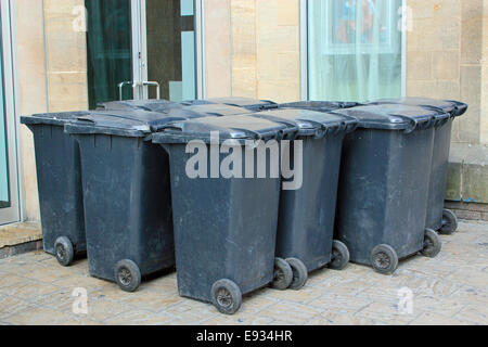 A large collection of black rubbish bins symbolizing waste disposal, household rubbish, recycling and environmental waste Stock Photo