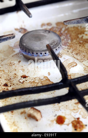 Old dirty gas cooker with flame burning. Stock Photo