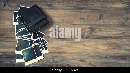 vintage instant photo frames and camera on rustic wooden background. retro style toned picture Stock Photo