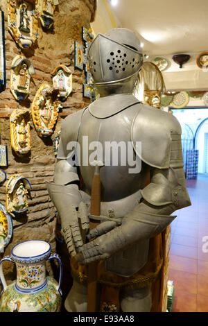 Medieval Knight armour in a Spanish pottery and ceramic shop with carafes on display in Mijas, Andalusia, Southern Spain. Stock Photo