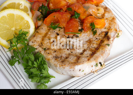 Marlin steak grilled and served with a tomato onion salsa viewed from above Stock Photo