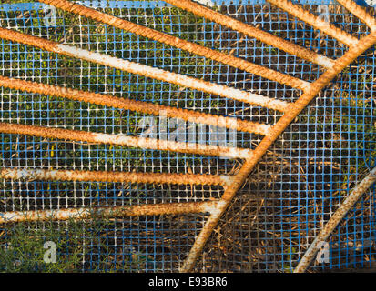 Colorful details of rusty old gate with blue plastic mesh, Samos Greece Stock Photo