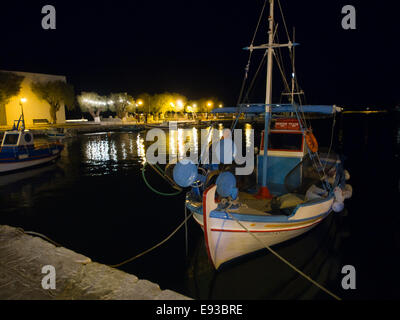 Greek fishing boat and colourful harbour lights, late evening or night in the harbour of  Pythagorion on Samos island in Greece Stock Photo