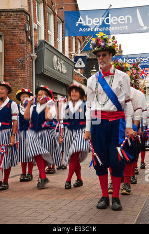 Vertical portrait of traditional North-West Morris dancers performing a formation dance in the street Stock Photo