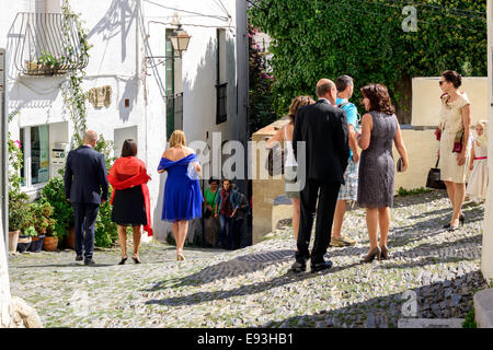 Well dressed people exit a church after attending a wedding in the town of Cadaques, Costa Brava. Stock Photo