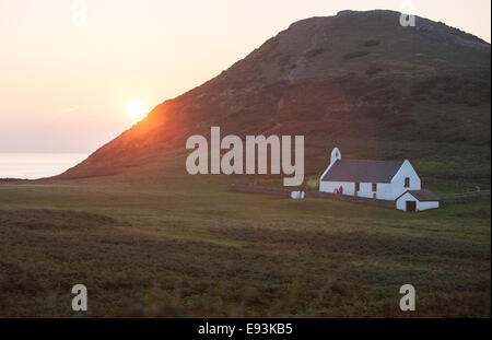 Church at Mwnt,on coast above Cardigan Bay,Ceredigion,West Wales.Mwnt is the triangular hill mound.Sunset,from caravan park. Stock Photo