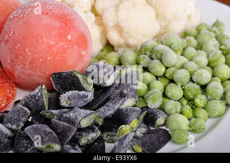 heap of frozen tomato, asparagus, peas and cauliflower Stock Photo