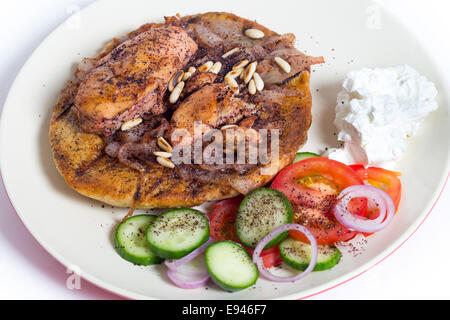 Musakhan, traditional Palestinian sumac chicken, on a plate with a salad and yoghourt, Stock Photo