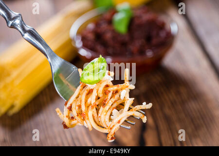 Spaghetti and Tomato Pesto on wooden background (close-up shot) Stock Photo
