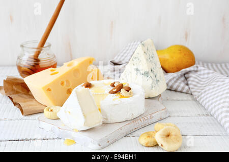 Different cheeses on a cutting board, delicious food Stock Photo