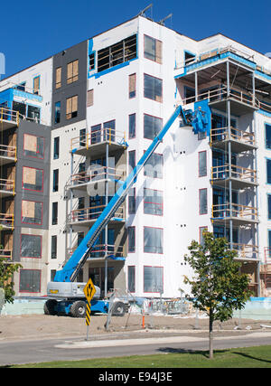 New building construction at Thunder Bay waterfront using Genie Terex cherry picker access platform Ontario, Canada Stock Photo