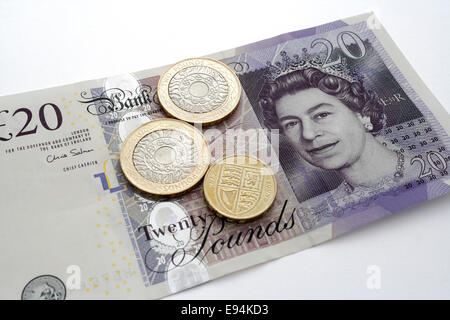 British £20 pounds note with coins Stock Photo