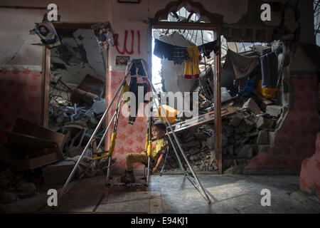 Gaza. 19th Oct, 2014. A Palestinian boy sits inside his house in Al-Shejaiya neighborhood, east of Gaza City on Oct. 19, 2014. Al-Shejaiya neighborhood was destroyed during the 50-day conflict between Israel and Hamas. © Wissam Nassar/Xinhua/Alamy Live News Stock Photo