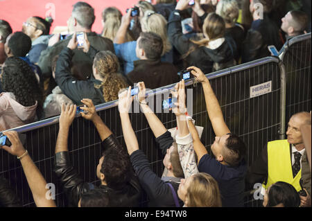 London, London, UK. 19th Oct, 2014. The European film premiere of Fury starring Brad Pitt takes place at the Odeon cinema in Leicester Square, London. Pictured: Fans outside the Red Carpet perimeter fence try to capture Brad Pitt on their smartphones. © Lee Thomas/ZUMA Wire/Alamy Live News Stock Photo