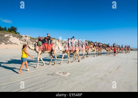 Tourists riding on camels on Cable Beach, Broome, Western Australia Stock Photo