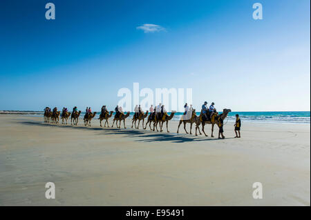 Tourists riding on camels on Cable Beach, Broome, Western Australia Stock Photo