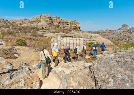 Hikers on trail through rocky landscape, erosion landscape, Isalo National Park, near Ranohira, Madagascar Stock Photo