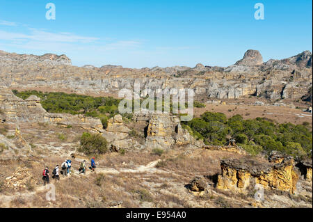 Hikers on trail through rocky landscape, erosion landscape, Isalo National Park, near Ranohira, Madagascar Stock Photo