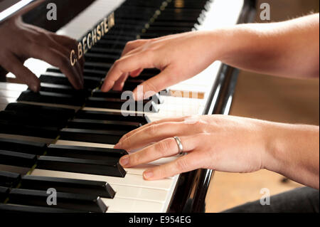 Woman's hands playing a Bechstein grand piano Stock Photo