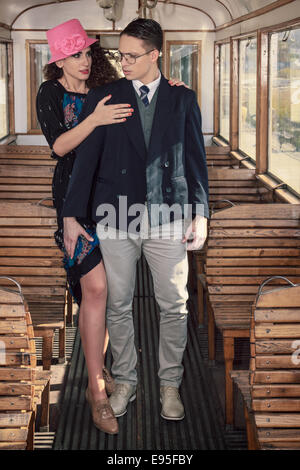Beautiful vintage style couple inside retro train coach have an argument and disagreements, fashion vintage style Stock Photo