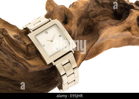 A mans wrist watch on a piece of fossilised wood - studio shot with a white background Stock Photo