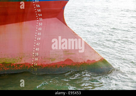 Draft marks on red bow of large ship Stock Photo