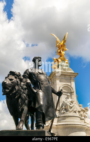 Rear view of Queen Victoria Memorial outside Buckingham Palace, London, with bronze statue of lion and man in foreground Stock Photo